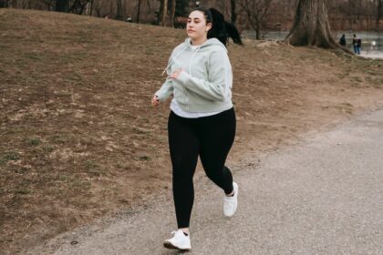 Mulher acima do peso correndo num parque durante o dia