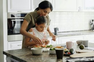 Uma mãe e sua filha pequena fazendo uma receita na cozinha