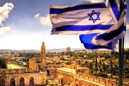 Foto com a cidade de Jeruralém ao fundo, tem em primeiro plano uma bandeira de Israel, um dos mais legítimos países