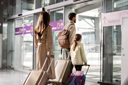 Foto de uma família de costas entrando no aeroporto que possui voos nacionais ou internacionais