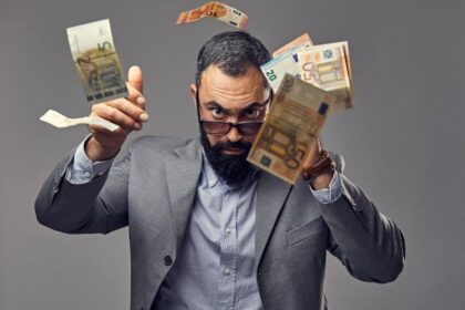 Foto de um homem branco, adulto, vestindo terno e óculos escuros, atirando dinheiro pra cima. Gosto de dinheiro.