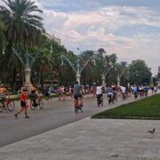 Foto de um parque com muitas pessoas caminhando no seu centro. Exemplos de cidades caminháveis.