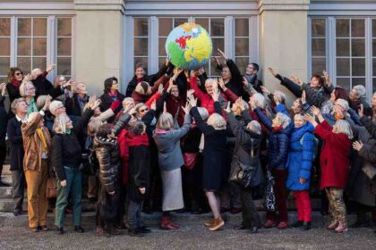 pessoas idosas estão reunidas em frente ao Tribunal de Direitos Humanos da Suíça comemorando a vitória numa ação sobre mudanças climáticas