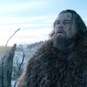 Foto do protagonista do filme O Regresso, Leonardo di Caprio, em meio a uma área nevada, com um casaco de pele de urso por cima.
