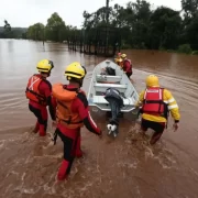 Fotos de voluntários da enchente do RS empurrando um barco dentro da água. Esses são os heróis, ou outros os sem-noção