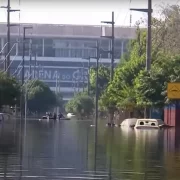 Foto de uma rua do Bairro Humaitá inundada pela enchente. Ao fundo está a Arena do Grêmio.