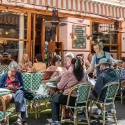 Foto de mesas na calçada de dia de um charmoso restaurante francês