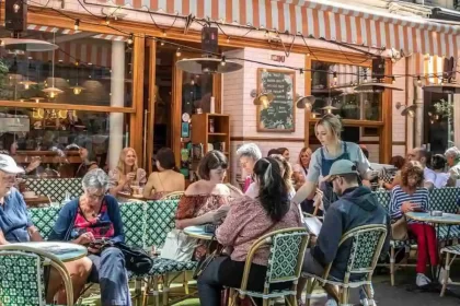 Foto de mesas na calçada de dia de um charmoso restaurante francês