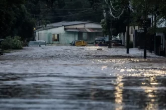 Foto de uma rua alagada na enchente do RS, uma casa ao fundo. Os ECEs ou Eventos Climáticos Extremos ocorrerão com mais frequência.