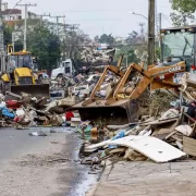 Foto de uma rua de Canoas cheia de lixo das enchentes. O negacionismo ainda reverbera