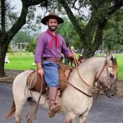 Foto do gaúcho Matteus Amaral, pilchado, em cima de um cavalo.