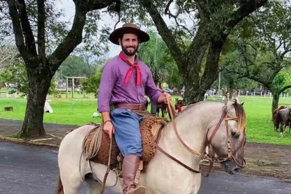 Foto do gaúcho Matteus Amaral, pilchado, em cima de um cavalo.