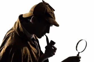 Uma figura caracteriza do personagem Sherlock Homes, com lupa e cachimbo,do escritor Conan Doyle