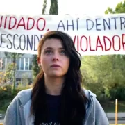 Cena do filme Não nos calaremos. Uma jovem, vítima de abuso, está em frente à escola denunciando os violadores.