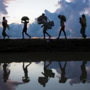 Foto de migrantes climáticos em fuga deixando os seus lares.