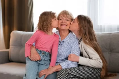 Foto de uma avó com as duas netas a beijando, a avosidade é uma benção.