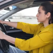 Foto de uma mulher dirigindo um carro de autoescola