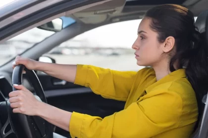 Foto de uma mulher dirigindo um carro de autoescola