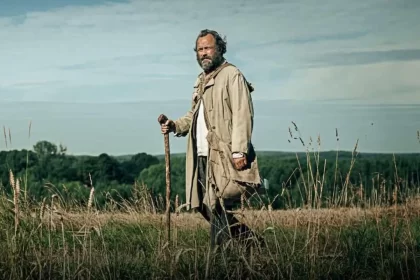 Homem caminha numa área rural, cena do filme amor esquecido