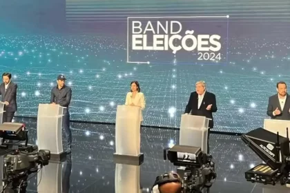 Foto do estúdio do debate em São Paulo. Tem candidato se apresentando como antipolítico