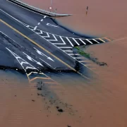 Foto aérea de uma estrada alagada pela enchente no RS, desastre ambiental no Brasil