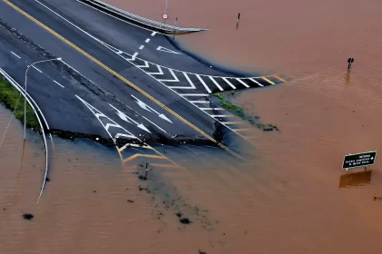 Foto aérea de uma estrada alagada pela enchente no RS, desastre ambiental no Brasil