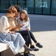 Foto de jovens num bando de praça olhando para o fone celular, que é por onde se constrói hoje o discurso político