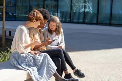 Foto de jovens num bando de praça olhando para o fone celular, que é por onde se constrói hoje o discurso político