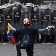 Imagem de policiais venezuelanos das forças de maduro enfileirados diante de um manifestante