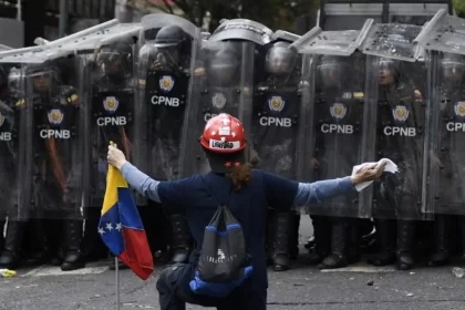 Imagem de policiais venezuelanos das forças de maduro enfileirados diante de um manifestante