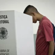 Foto de um rapaz numa cabine de votação. Candidatas e candidatos serão escolhidos este ano