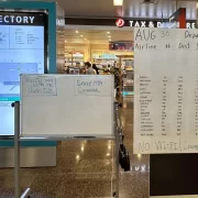 Foto de cartazes escritos à mão no aeroporto de Seatle, sem poder se conectar