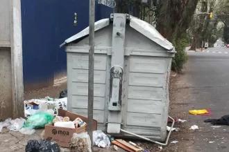 Foto de um container de lixo, com lixo à volta, em Porto Alegre. Eleições são só promessas