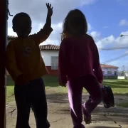 Foto de duas crianças de costas na porta de casa. Investigação da paternidade