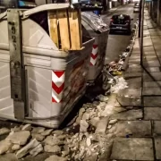 Foto de um Contêiner numa rua de porto alegre, com as sacolas de lixo espalhadas pelo chão