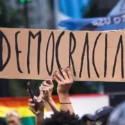 Foto de um cartaz de papelão, numa manifestação, com a palavra democracia