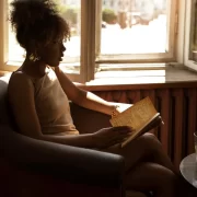 Foto de uma mulher negra, jovem, sentada numa poltrona. Autora fala da Feira do Livro de Porto Alegre