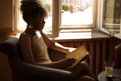 Foto de uma mulher negra, jovem, sentada numa poltrona. Autora fala da Feira do Livro de Porto Alegre