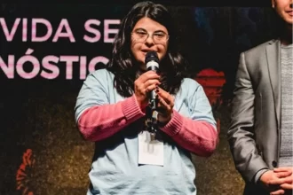 Fernanda Machado com microfone na mão, ela fala de oportunidades para pessoas com deficiência