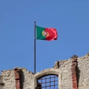 Foto da bandeira de portugal no alto de um castelo. A língua portuguesa é a última flor do láscio