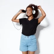 Uma jovem negra dançando com fones, ouvindo músicas