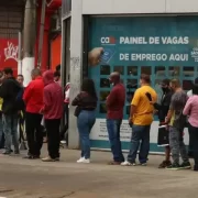 Foto mostra a fila de pessoas se candidatando a um emprego. Autor defende a economia budista