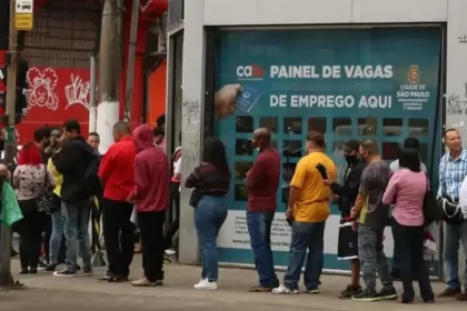 Foto mostra a fila de pessoas se candidatando a um emprego. Autor defende a economia budista