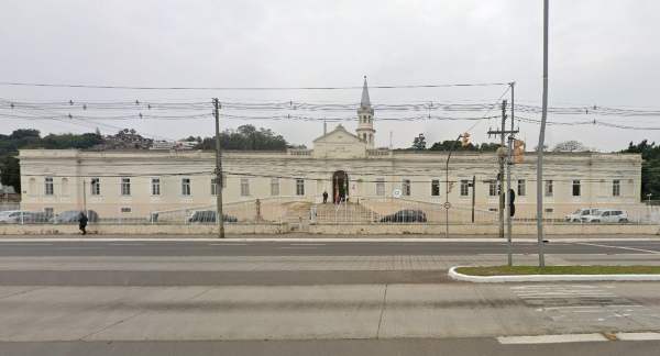 Imagem frontal do Asilo Padre cacique, em Porto Alegre. Autor cita a arquitetura do prédio.