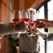 Várias mãos de amigos fazendo um brinde com taças de vinho