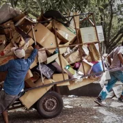 Dois catadores com uma carrocinha carregada de papelão. Autor fala sobre o trabalho humano