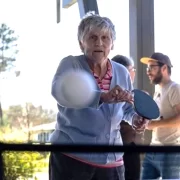 Mulher idosa joga ping pong na Vila Alzheimer