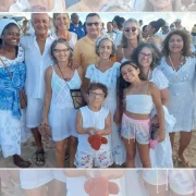 Foto da autora com vários amigos na beira da praia na Bahia