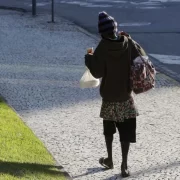 Foto de um morador de rua andando numa calçada. É uma população que sofre com a violência do estado