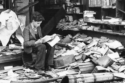 Em 1940, em Londres, uma pessoa sentada em escombros, faz a leitura de um livro